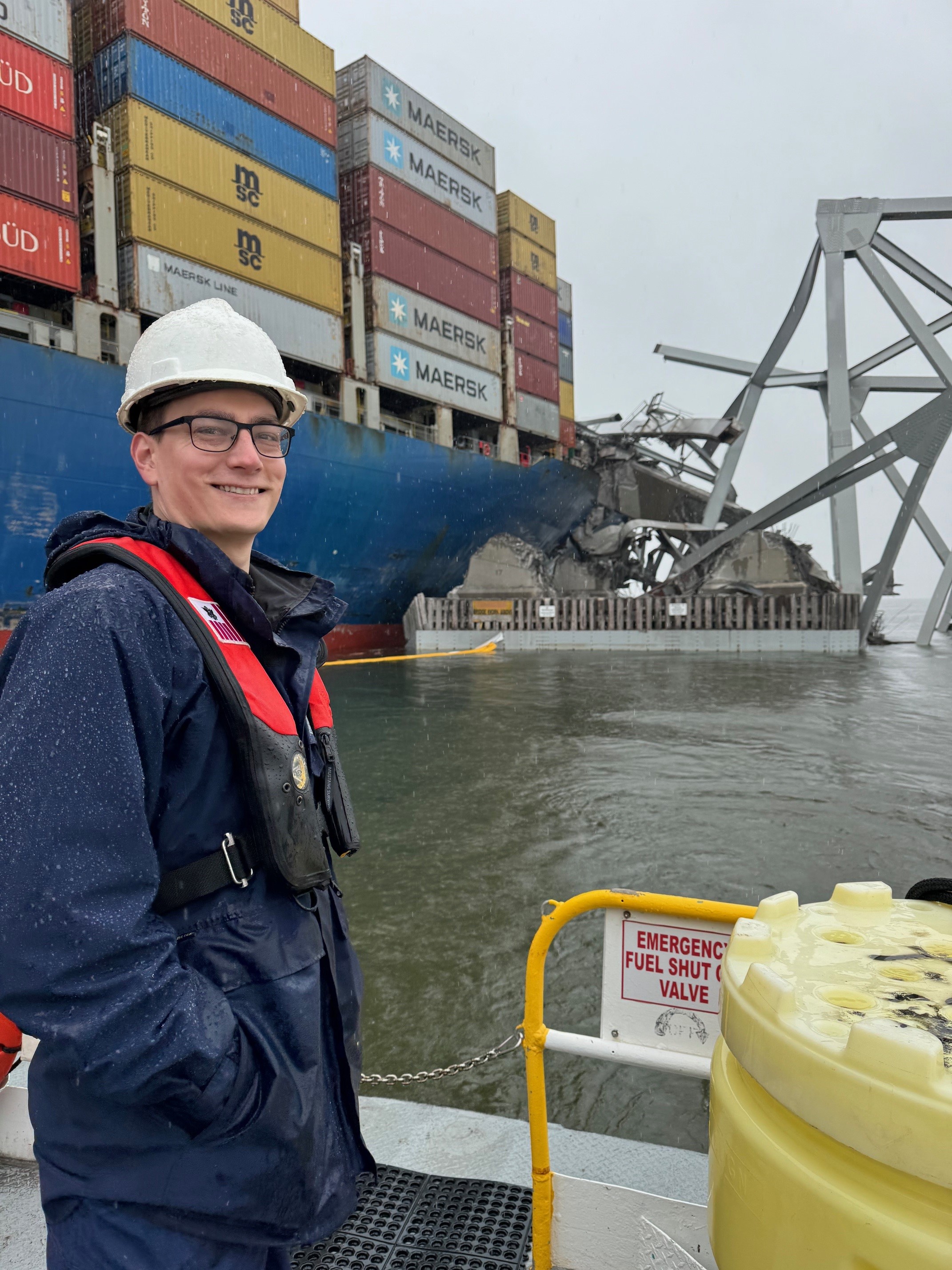 Member of SERT team posing in front of the Dali Bridge Collapse